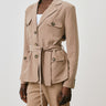 Person wearing a beige suit with a white background