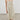 A woman modeling a saga midi dress with a smocked bodice, thin shoulder straps, and a gathered skirt, paired with brown suede flats against a neutral studio background.